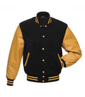 Front pose view of a black wool varsity jacket with gold leather sleeves, gold snap buttons, and one hand inserted in the side pocket.