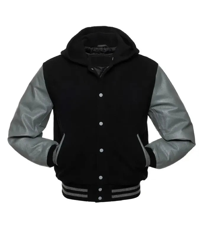Front view of a black hooded varsity jacket featuring grey contrast leather sleeves, both hands in pockets, silver snap closures, and hood.