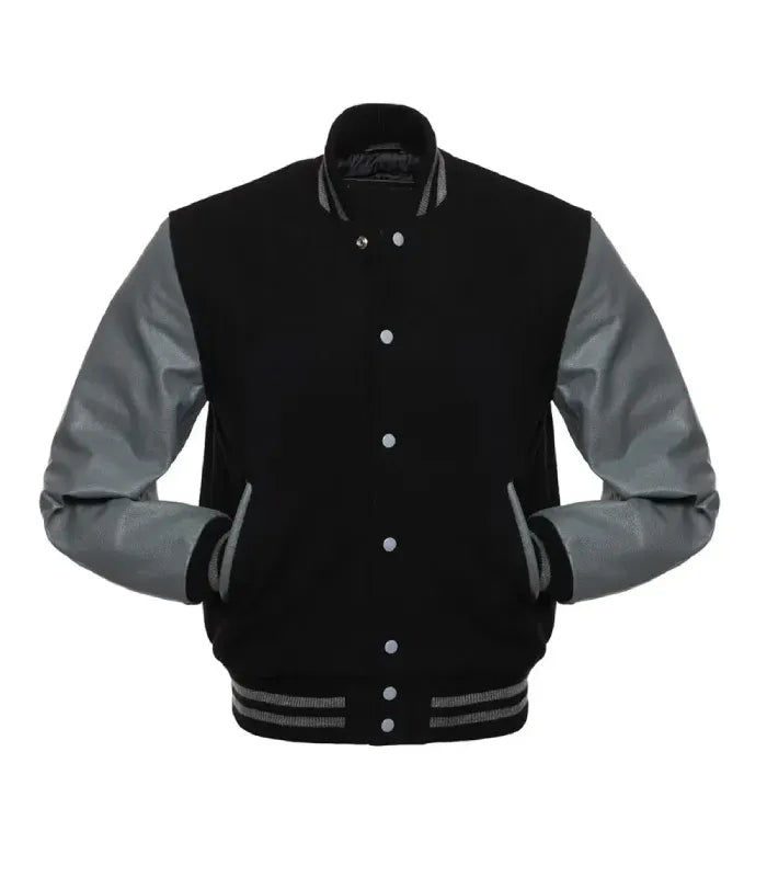 Front view of a classic black varsity jacket featuring grey contrast leather sleeves, both hands in pockets, and grey-striped rib trim collar.