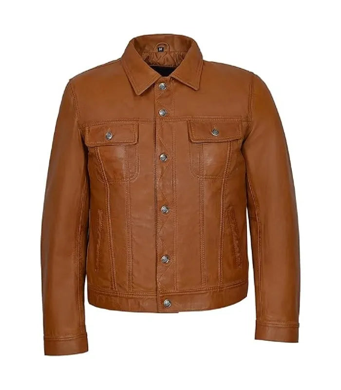 Direct front view of a tan brown leather trucker jacket featuring buttoned chest pockets and side welt pockets.