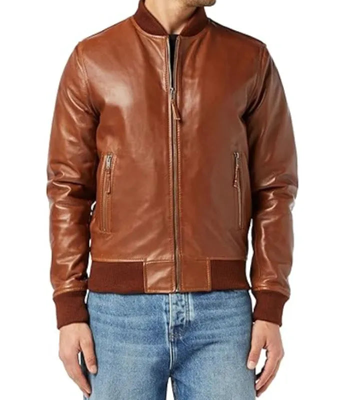 Front view model shot of a brown varsity bomber jacket styled with blue jeans, featuring ribbed collar, waist hem, and zipped pockets.