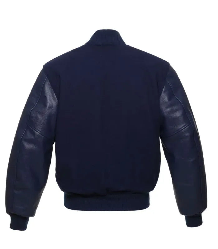 Clean back profile of dark navy wool varsity jacket featuring full leather sleeves and solid ribbed hem.