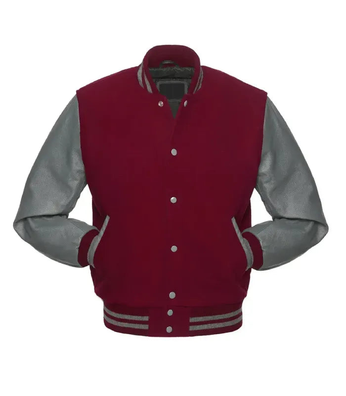 A classic varsity jacket with a deep red wool body and contrasting gray leather sleeves, featuring gray ribbed trim and silver buttons.