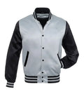 A varsity-style bomber jacket with a silver satin body and black sleeves, featuring a black button closure, striped ribbed collar, cuffs, and hem, and pockets.
